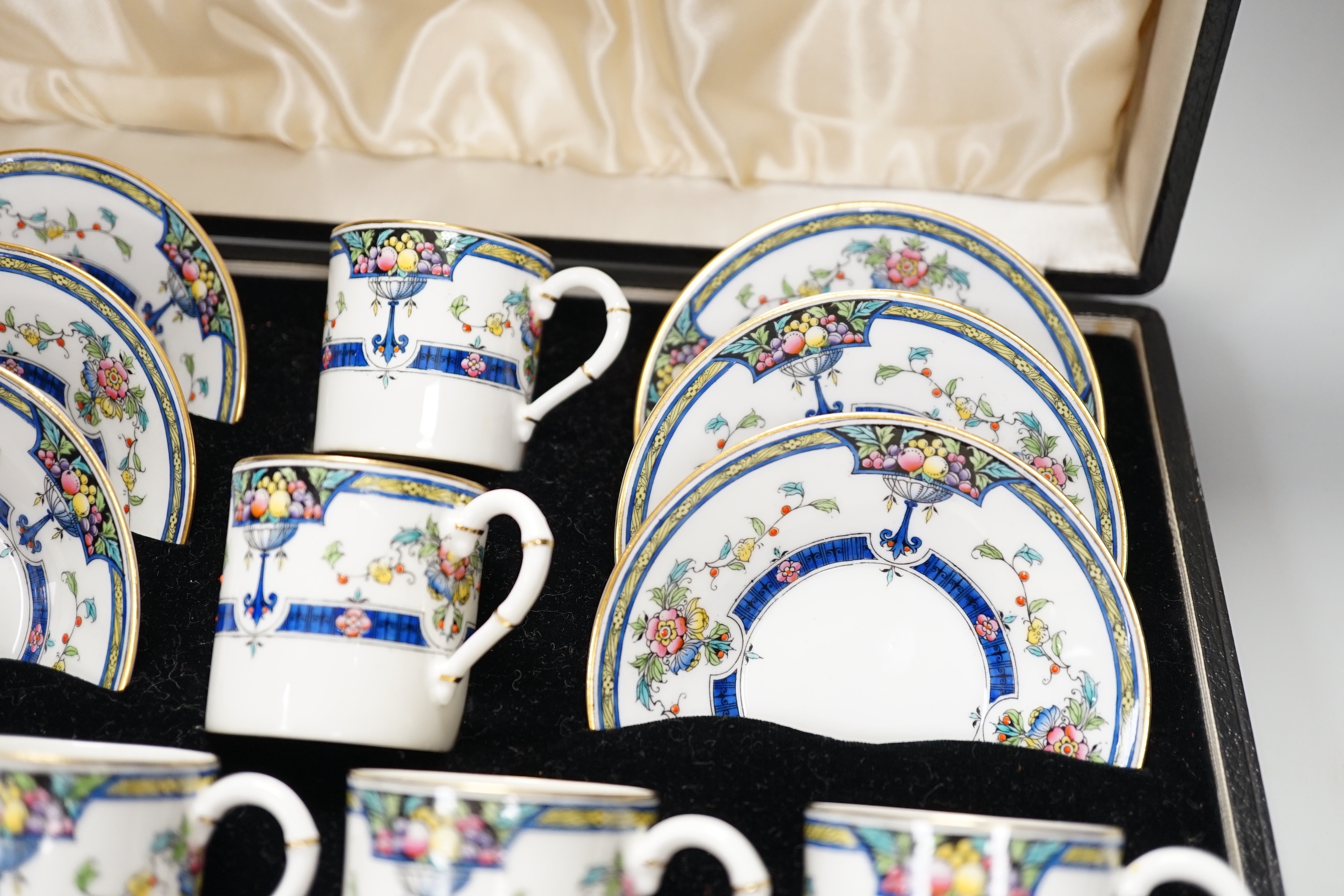 A cased Royal Worcester ‘Orlando’ coffee set with silver spoons